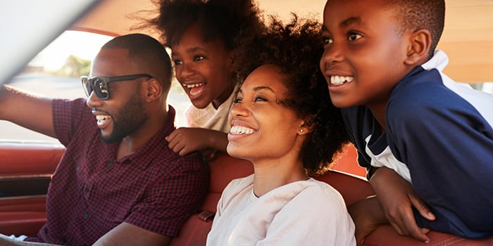 Beautiful happy family enjoying a drive in their vehicle
